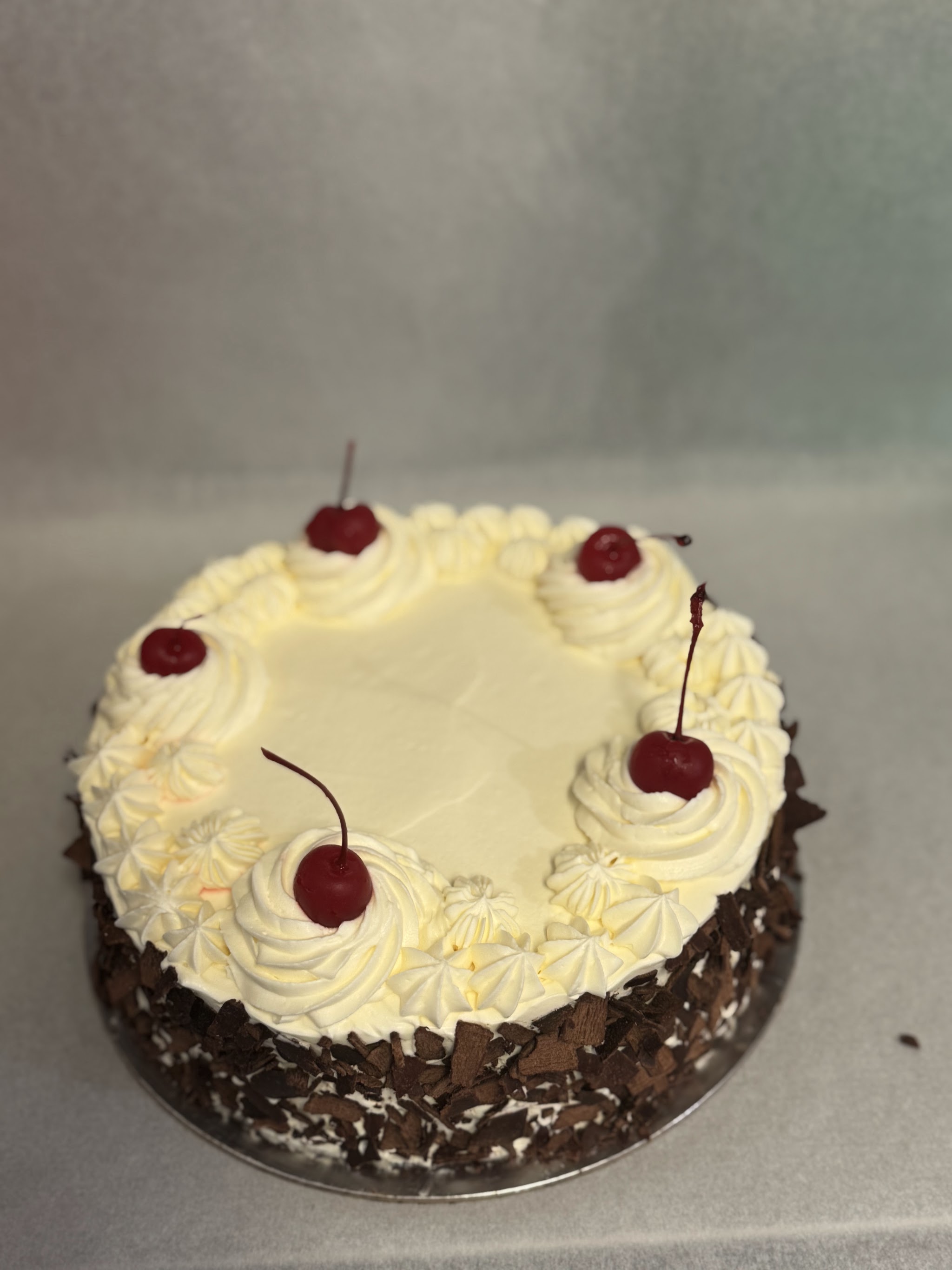 Black forest cake with whipped cream rosettes and cherries