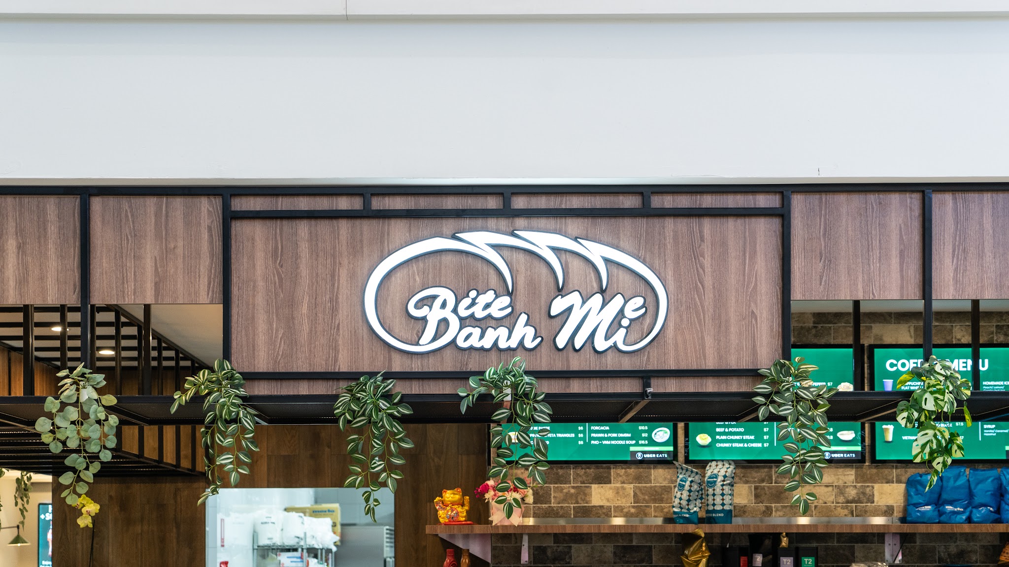 The lit Bite Banh Mi sign above the menu screens